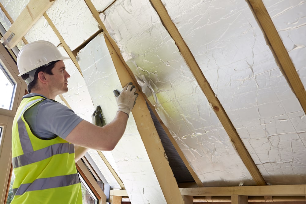 a professional insulating a house - How Quality Insulation Can Reduce Your Energy Bills