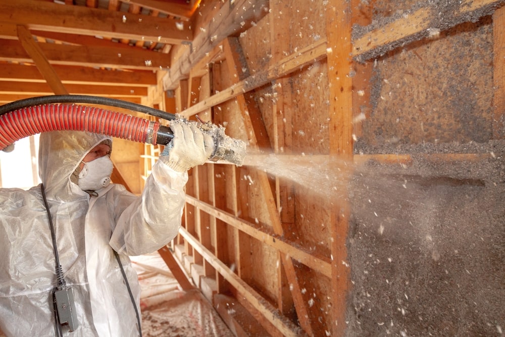 Spraying cellulose insulation on the wall - The Ins and Outs of Home Insulation: Why It Matters for New Orleans