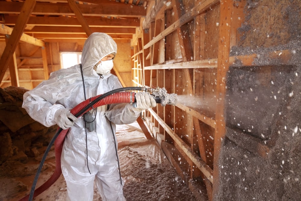 A worker Spraying cellulose insulation on the wall - Why Insulation Matters: Comfort, Efficiency, and Sustainability