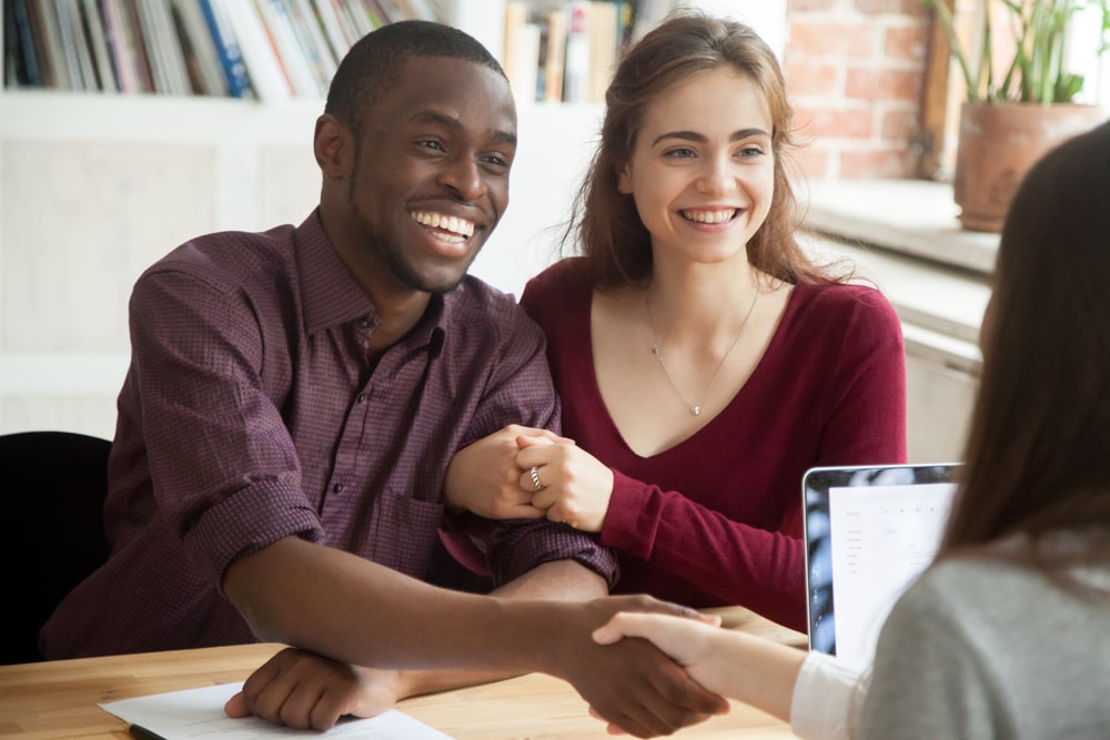 Multiethnic couple describing their dream house to a worker for insulation services