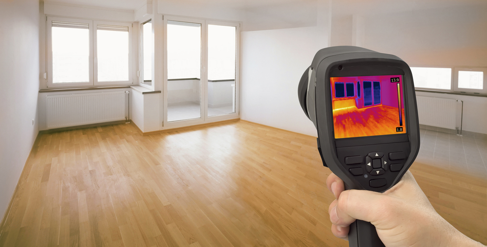 Thermal image showing heat escaping through windows, illustrating the importance of sealing air leaks for effective insulation in New Orleans homes